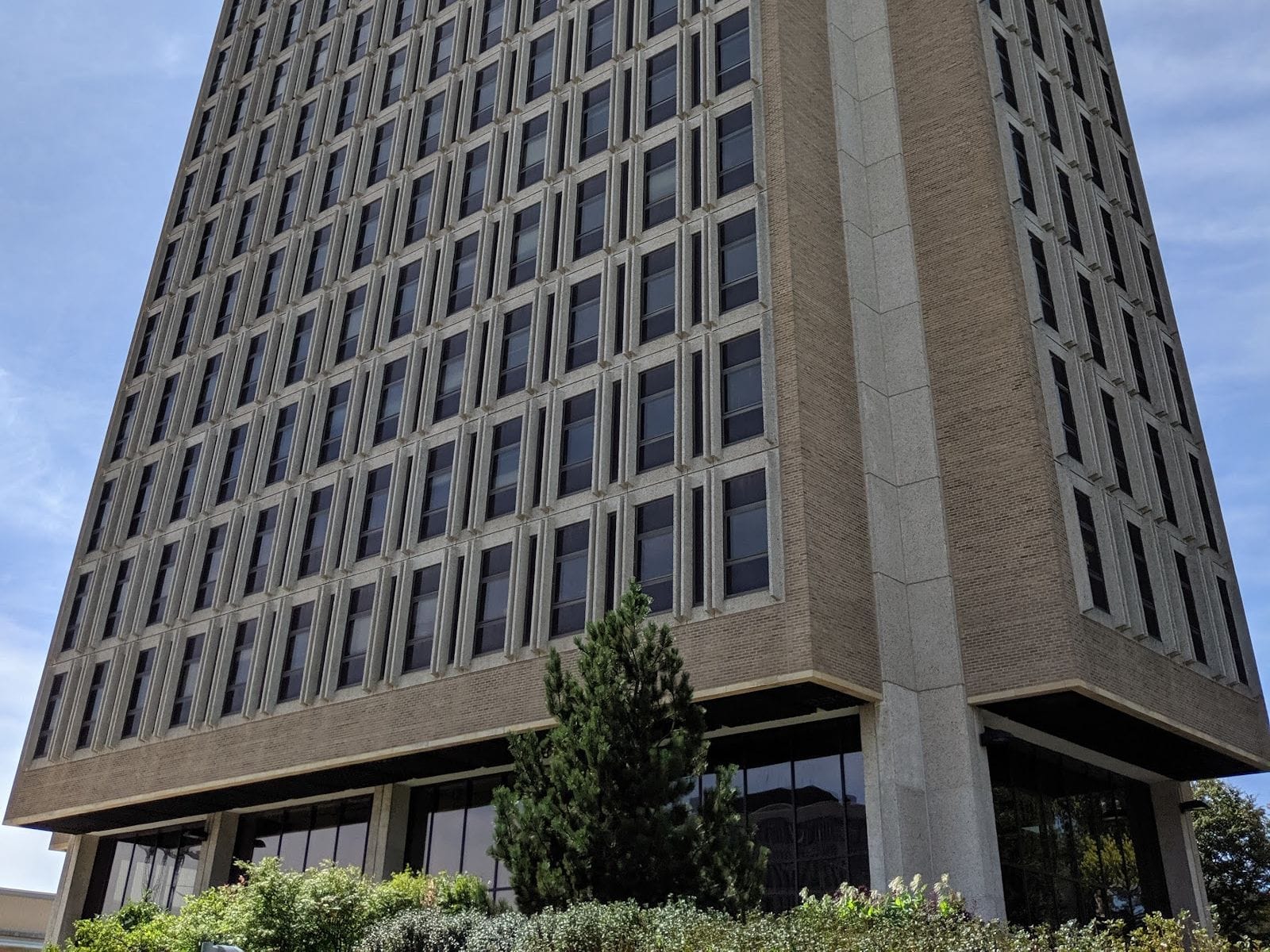 Modern architectural design of Van Hise Hall with large windows and greenery in front.