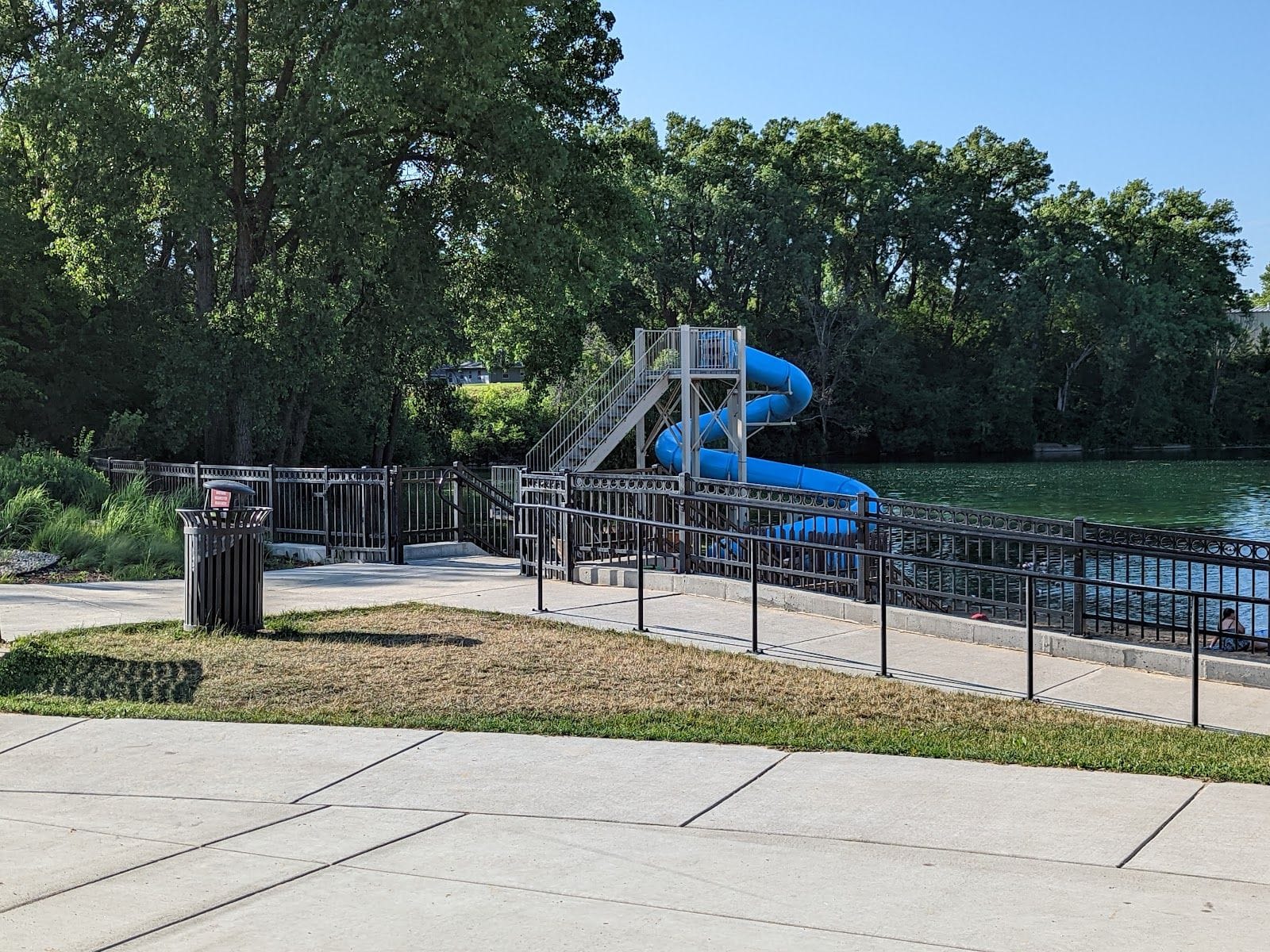 Scenic view of Fireman's Park Beach featuring a blue water slide and lush greenery.