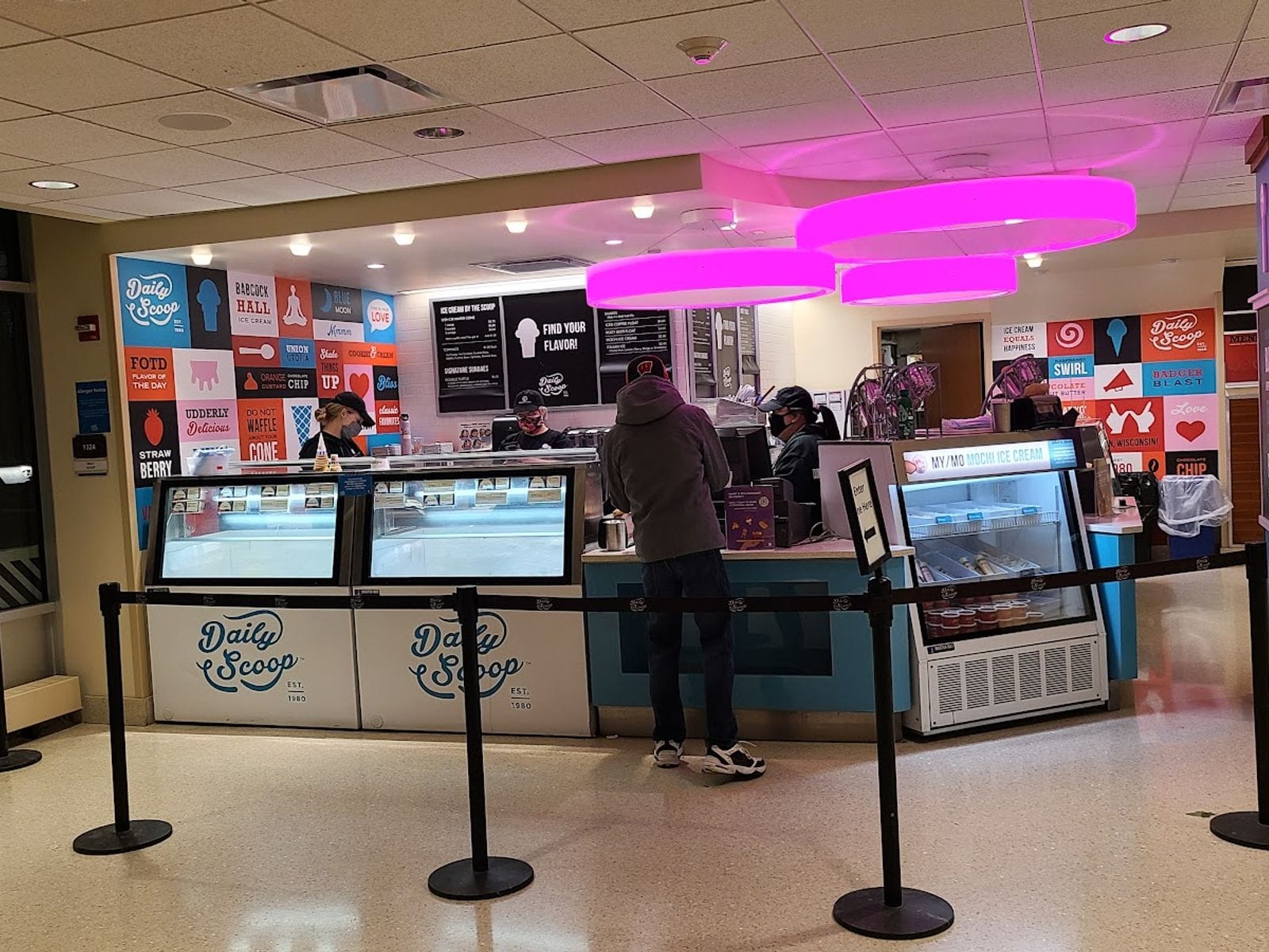 Customer orders ice cream at a brightly lit Daily Scoop counter inside Memorial Union.