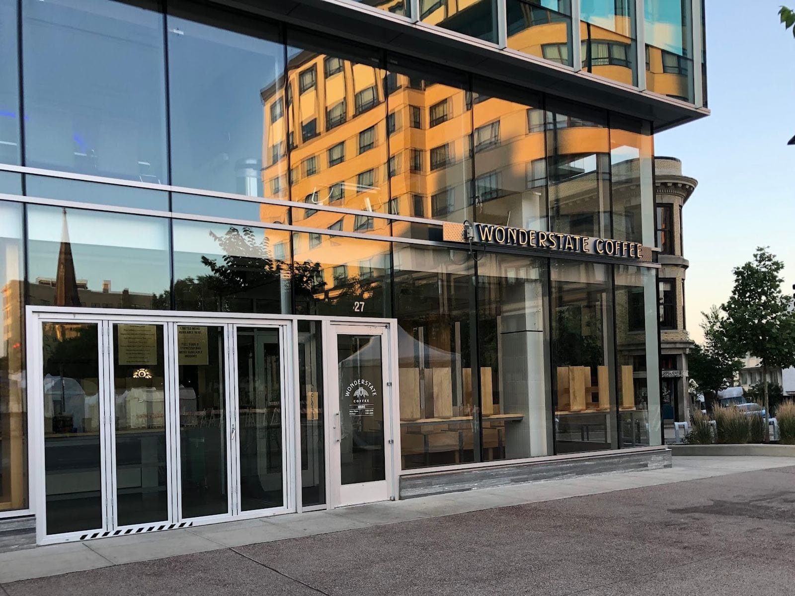 Glass-front Wonderstate Coffee cafe with sunlit reflections on Capitol Square in downtown Madison.