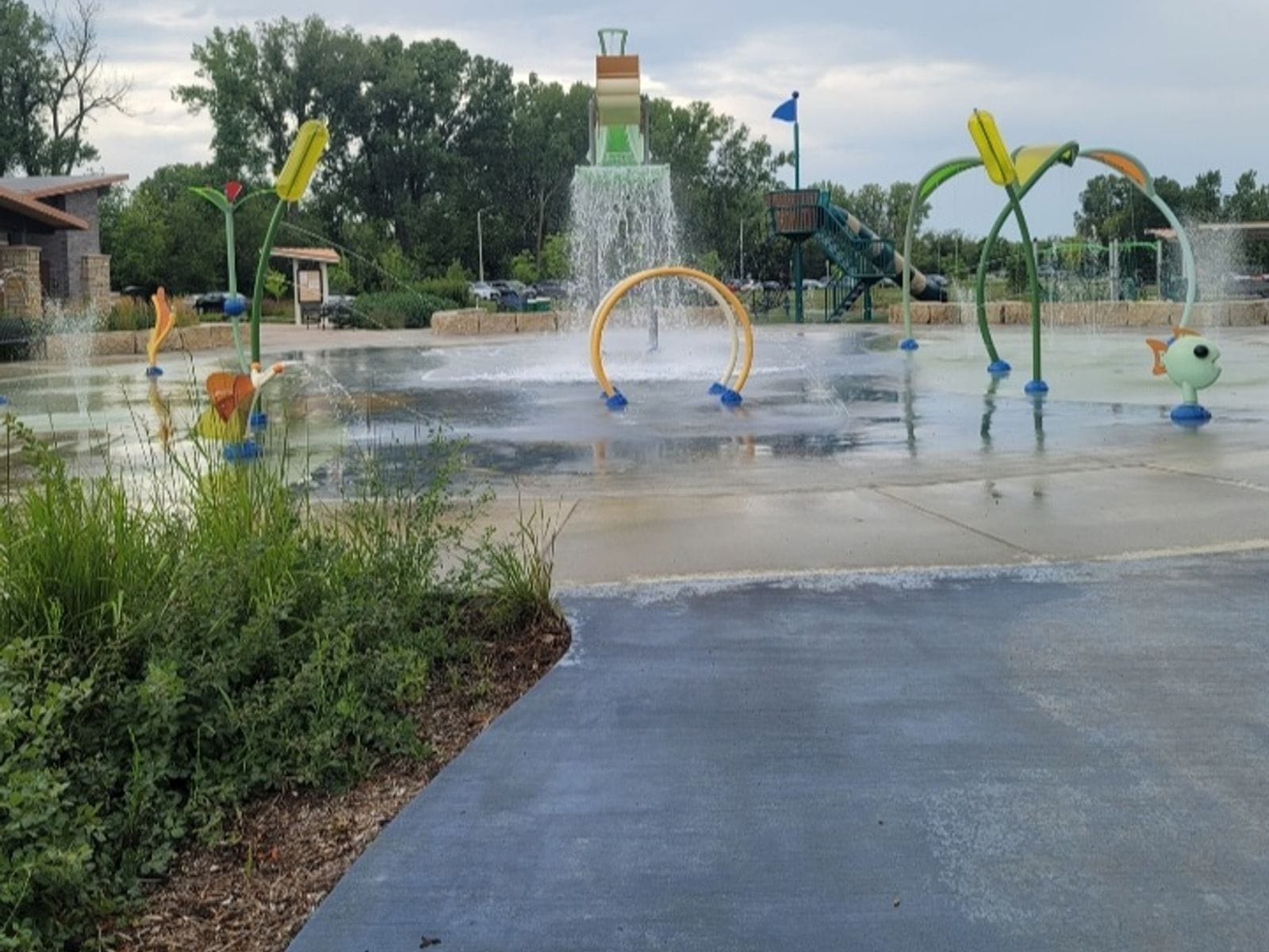 Colorful splash pad with water features and playground at Fireman's Park Beach, Verona, Wisconsin.