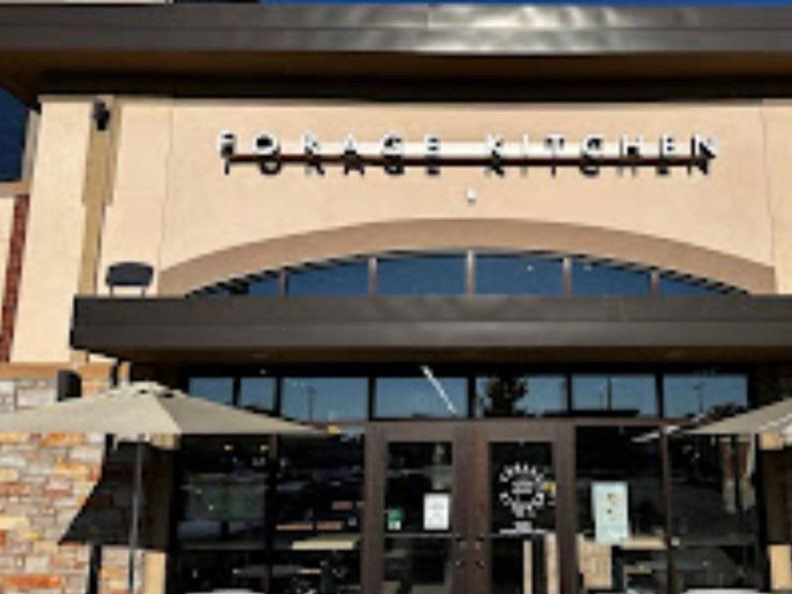 Exterior of Forage Kitchen with large windows, patio umbrellas, and a modern sign above the entrance.