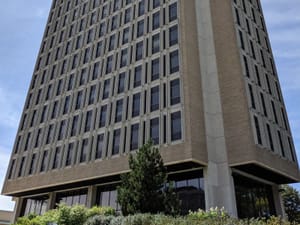 Modern architecture of Van Hise Hall with lush greenery in the foreground.