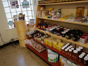 Shelves filled with Wisconsin-themed mugs, honey, maple syrup, snacks, and local gifts in a cozy shop.