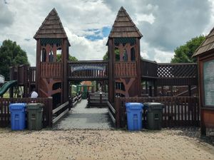 Large wooden playground structure with towers and a sign reading "Kids' Crossing" at McKee Farms Park.