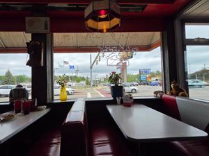 Cozy red vinyl booths and vintage decor inside Denny’s Diner, overlooking a busy street in Wisconsin Dells.
