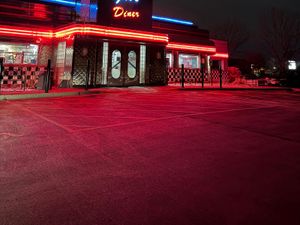 Gus's Diner exterior with red neon trim, chrome panels, double glass doors and checkerboard tile facade