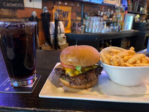 Cheeseburger with melted cheddar, crinkle fries and dark soda on Third Street Tavern bar.