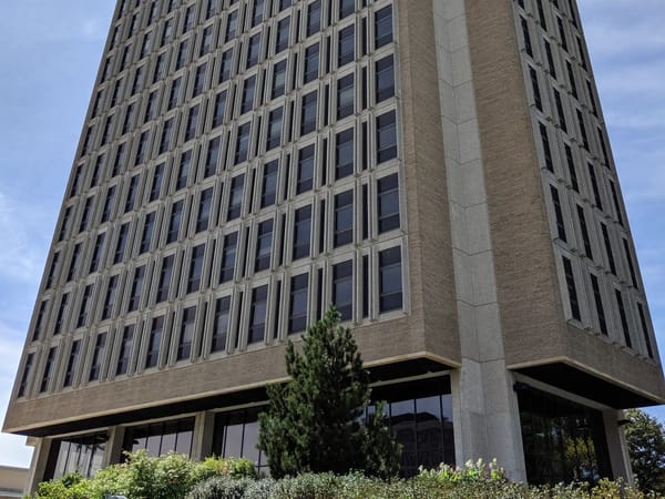 Modern architecture of Van Hise Hall with lush greenery in the foreground.