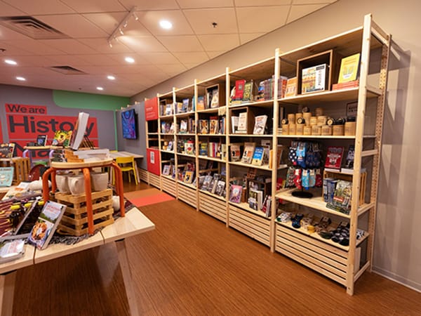 Cozy interior of History Maker Space showcasing local crafts and books on wooden shelves.