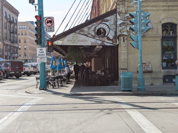 Outdoor seating at The Wicked Hop, bustling with guests under a decorative awning in Milwaukee’s Third Ward.