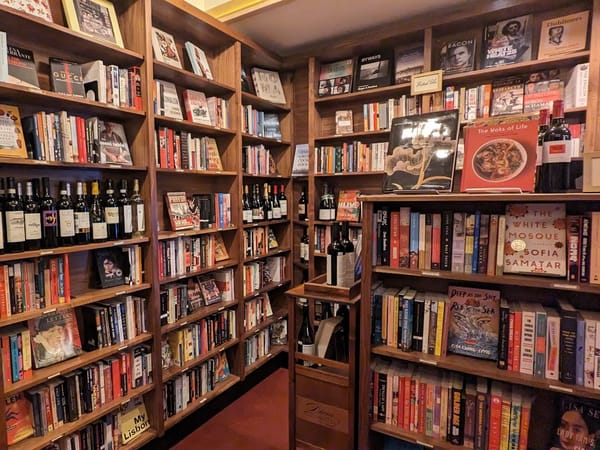 Cozy wooden bookshelves filled with books and wine bottles at Leopold's Books Bar Caffè in Madison, WI.