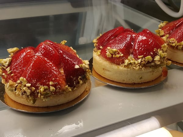 Strawberry tarts topped with chopped pistachios on display at Madison Sourdough bakery.